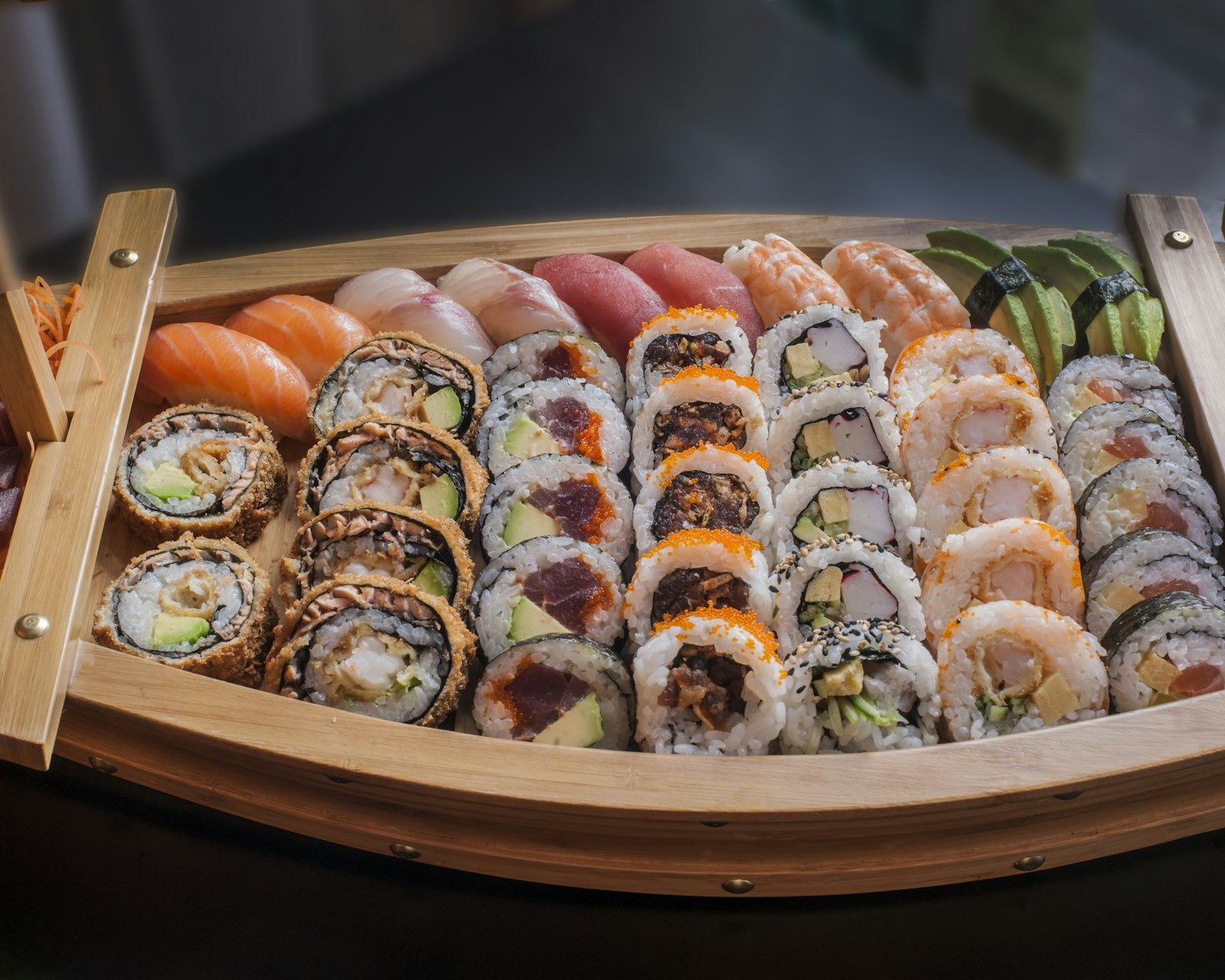 Aneka sushi dan sashimi tersaji di atas wadah kayu